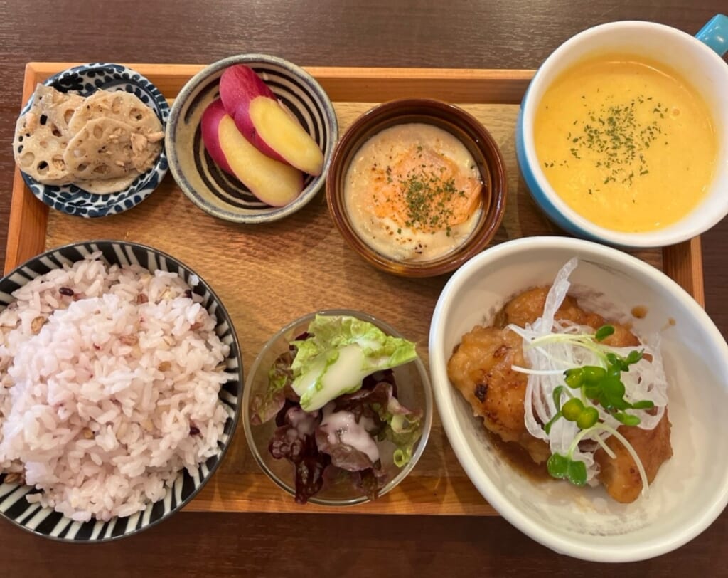 アシェットランチ1,400円の全体。木のトレーにチキンのシャリアピンソース、スープ、グラタン、小鉢、十六穀米(私が撮影)