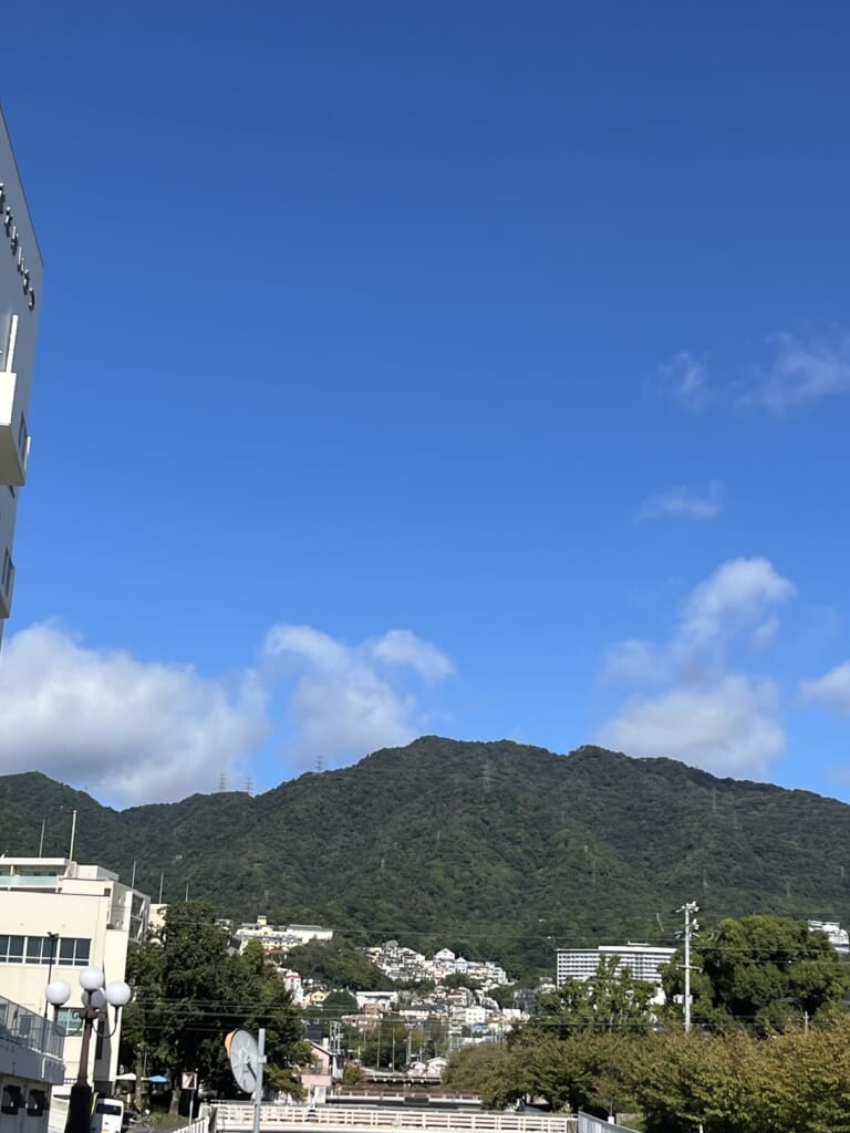 都賀川の橋の上から北を見ると、青空の下に六甲の山並み(私が撮影)